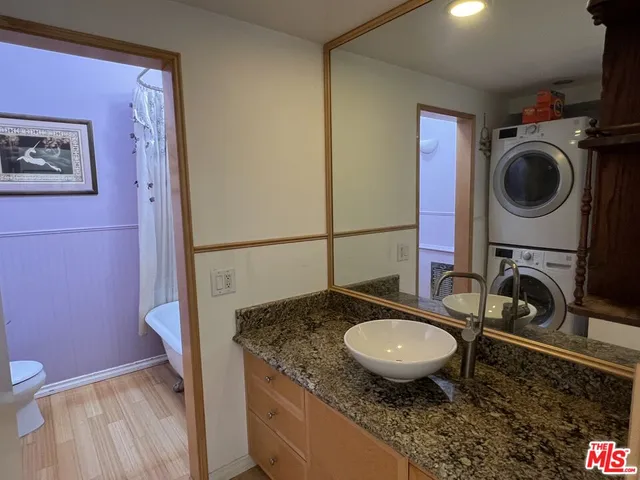 a bathroom with a granite countertop toilet a sink and a mirror