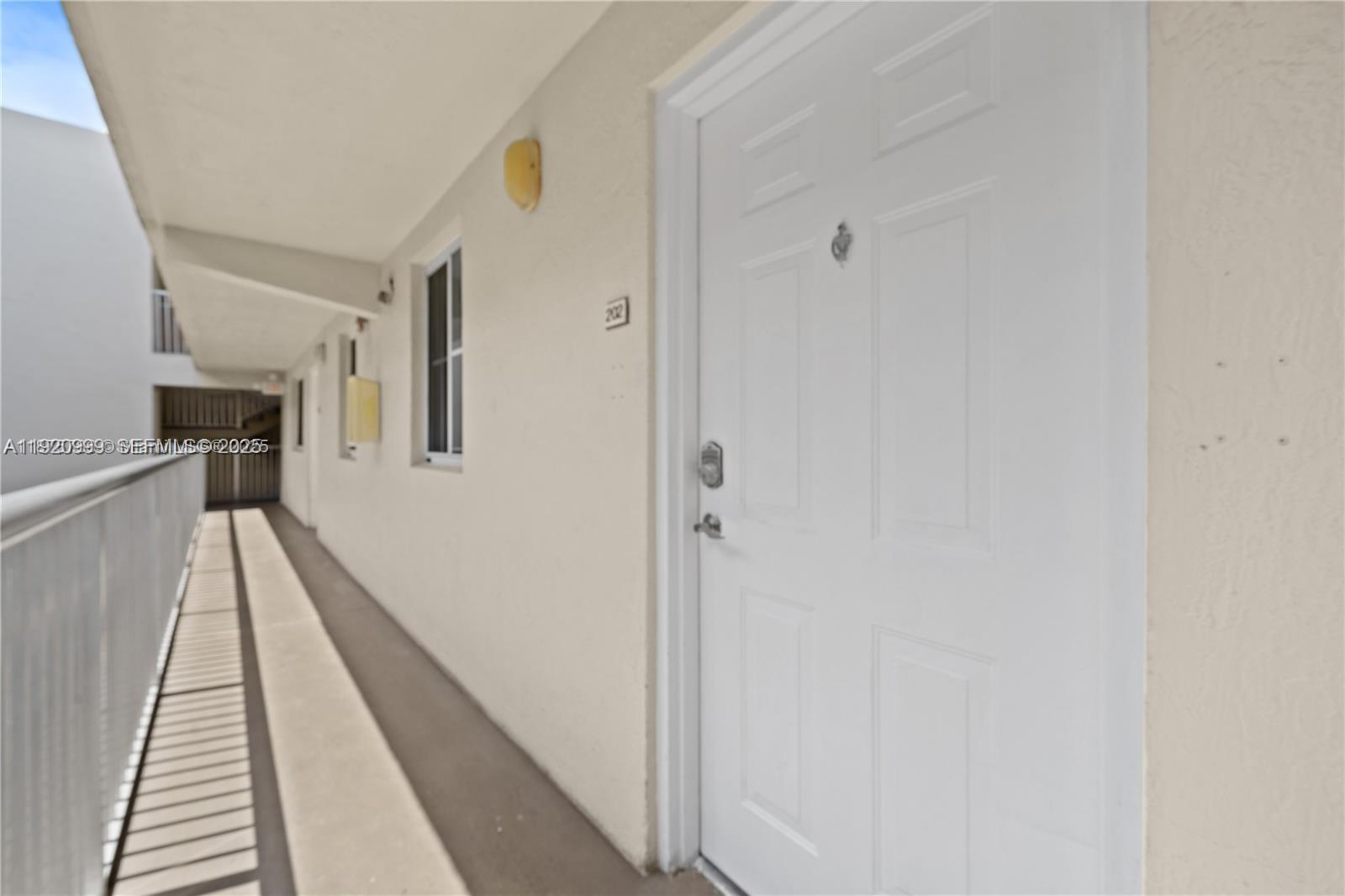 6135 Northwest 186th Street, Unit 202 Hialeah, FL 33015 - Photo 1 of 21 a view of a hallway with wooden floor and staircase