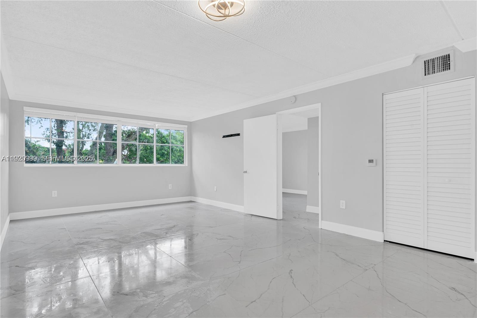 6135 Northwest 186th Street, Unit 202 Hialeah, FL 33015 - Photo 2 of 21 an empty room with windows