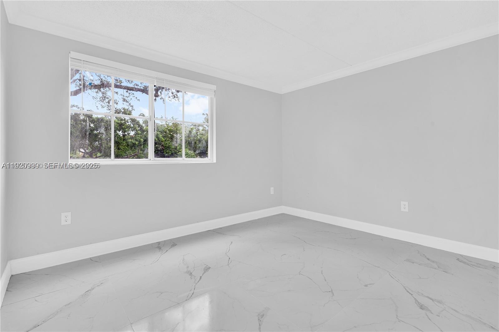 6135 Northwest 186th Street, Unit 202 Hialeah, FL 33015 - Photo 4 of 21 an empty room with a window