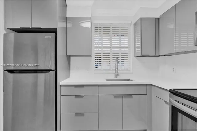 a kitchen with a sink a refrigerator and cabinets