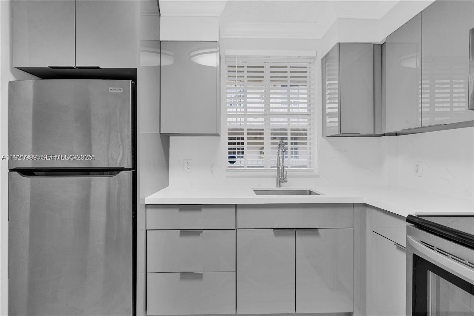 6135 Northwest 186th Street, Unit 202 Hialeah, FL 33015 - Photo 7 of 21 a kitchen with a sink a refrigerator and cabinets