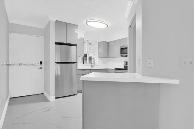 a kitchen with refrigerator and cabinets