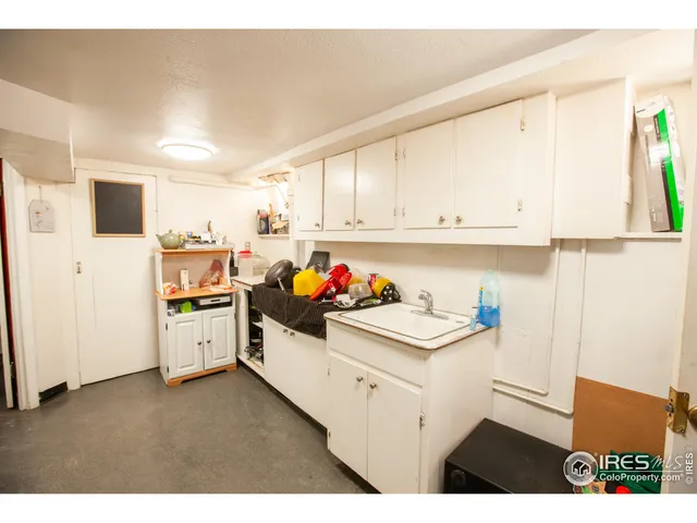 a kitchen with a sink a stove and white cabinets
