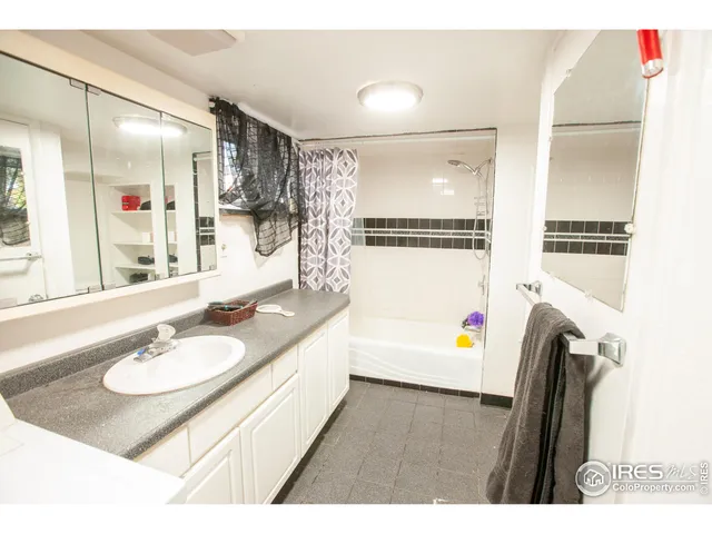 a bathroom with a sink double vanity mirror and a bathtub
