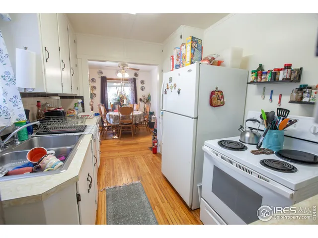 a kitchen with a refrigerator a stove and wooden floor