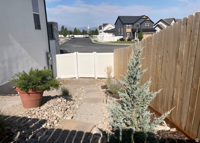 655 Oliver Road Tooele, UT 84074 - Photo 20 of 21 Side yard featuring a gravel and paver pathway, a privacy fence, and planted shrubbery
