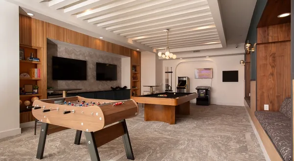 a living room with furniture a flat screen tv and kitchen view