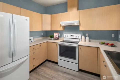 a kitchen with stainless steel appliances a sink a refrigerator and a window
