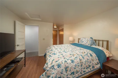 a bedroom with a bed and a flat tv screen on a dresser