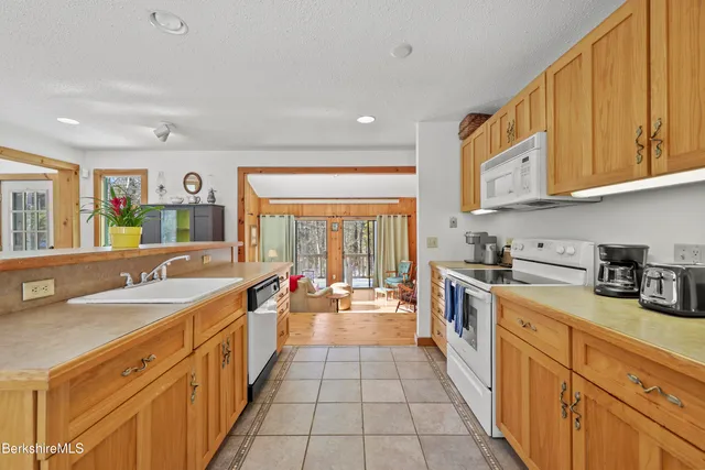 a living room with stainless steel appliances kitchen island granite countertop furniture and a wooden floor