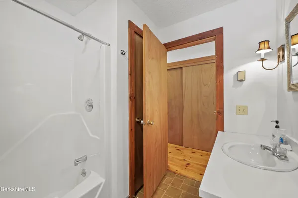 a bathroom with a granite countertop sink a toilet a shower and a mirror