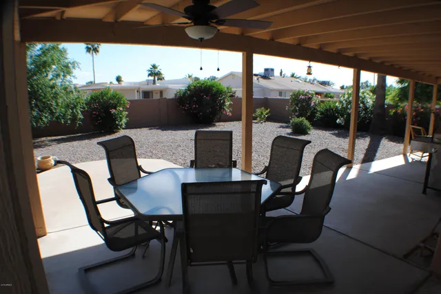 a view of a patio with chairs and floor to ceiling window