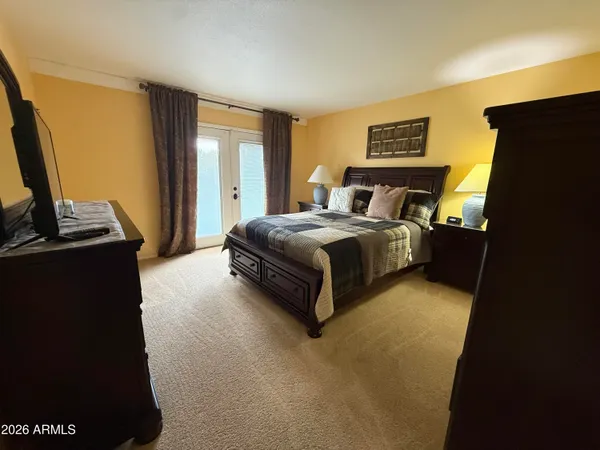 a spacious bedroom with a bed and a flat screen tv