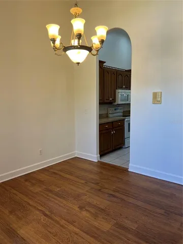 a view of a livingroom with a chandelier wooden floor and chandelier