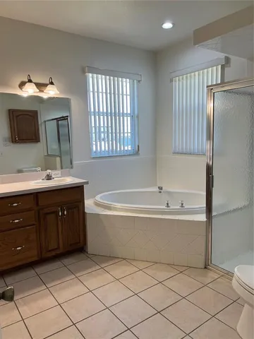 a spacious bathroom with a double vanity sink mirror and bathtub