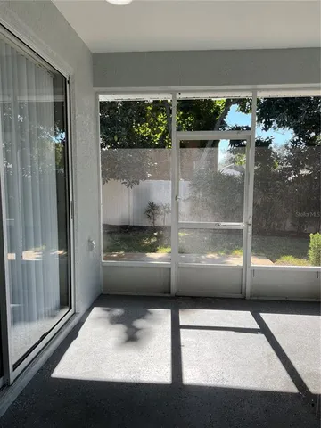 a bedroom with a large bed and large windows