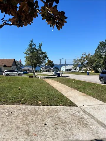a view of a hallway with wooden floor and a living room