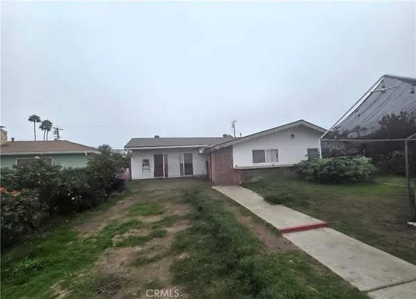 a view of a house with a yard and potted plants
