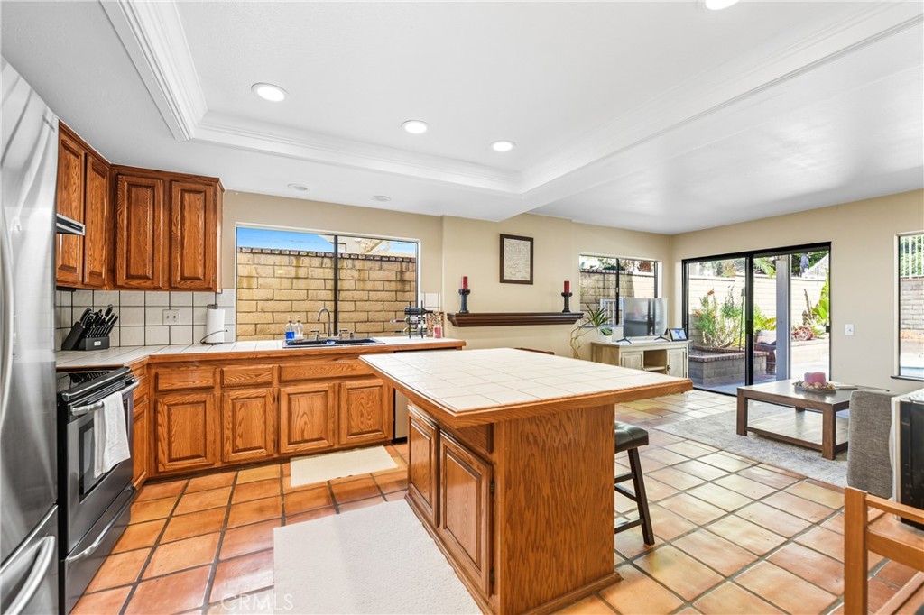 21902-21902 Raintree Lane Lake Forest, CA 92630 - Photo 13 of 46 a large kitchen with stainless steel appliances kitchen island granite countertop a sink and cabinets