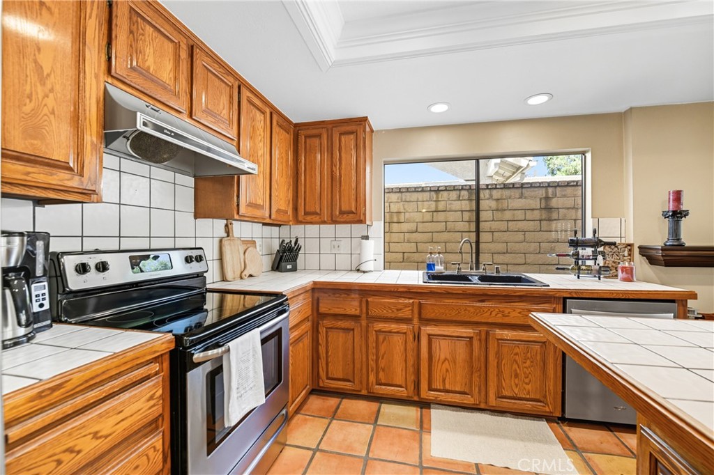 21902-21902 Raintree Lane Lake Forest, CA 92630 - Photo 14 of 46 a kitchen with a sink stove and cabinets