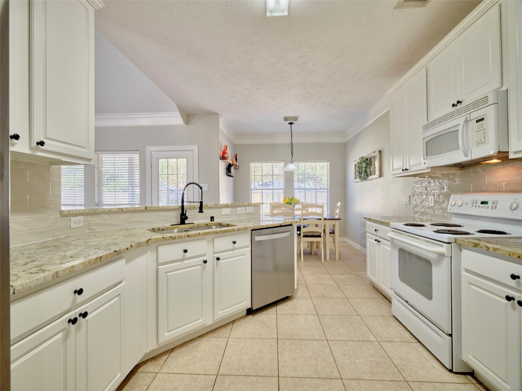 9315 Anna Street Needville, TX 77461 - Photo 21 of 46 a kitchen with a sink stove and cabinets