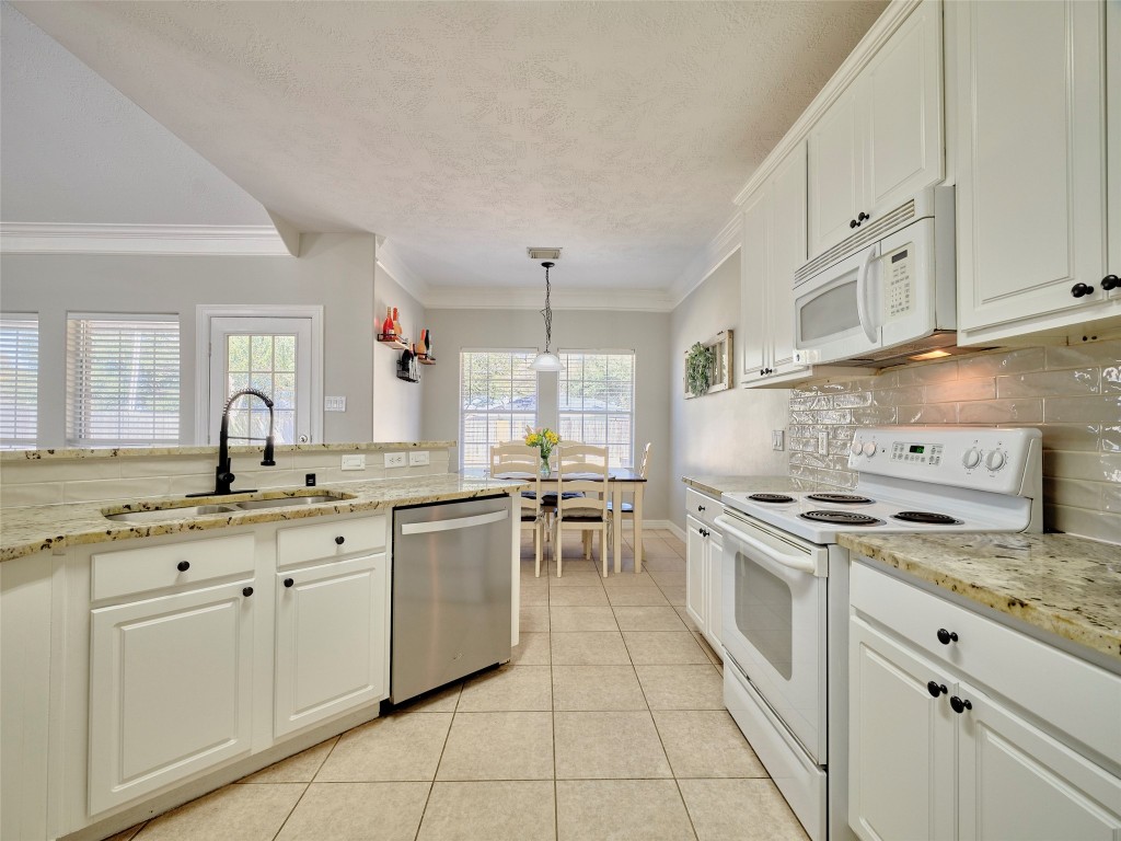 9315 Anna Street Needville, TX 77461 - Photo 22 of 46 a kitchen with a stove sink and cabinets