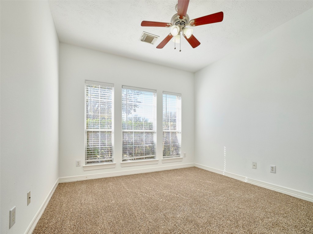 9315 Anna Street Needville, TX 77461 - Photo 32 of 46 an empty room with chandelier fan and windows