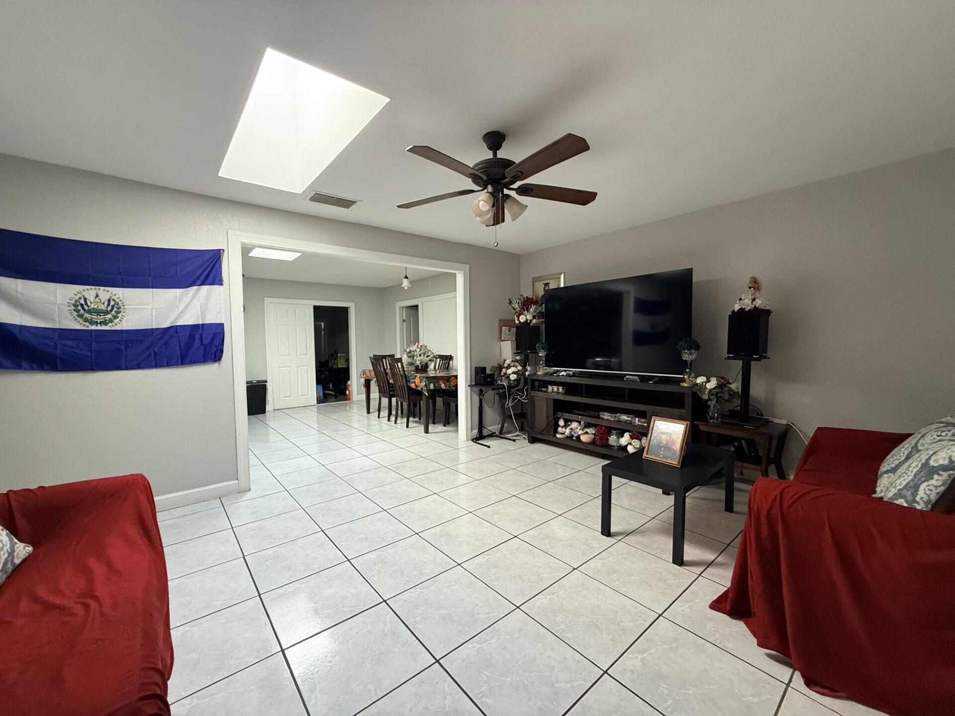 4904 Myrtle Drive Fort Pierce, FL 34982 - Photo 4 of 18 a living room with furniture and a flat screen tv with kitchen view