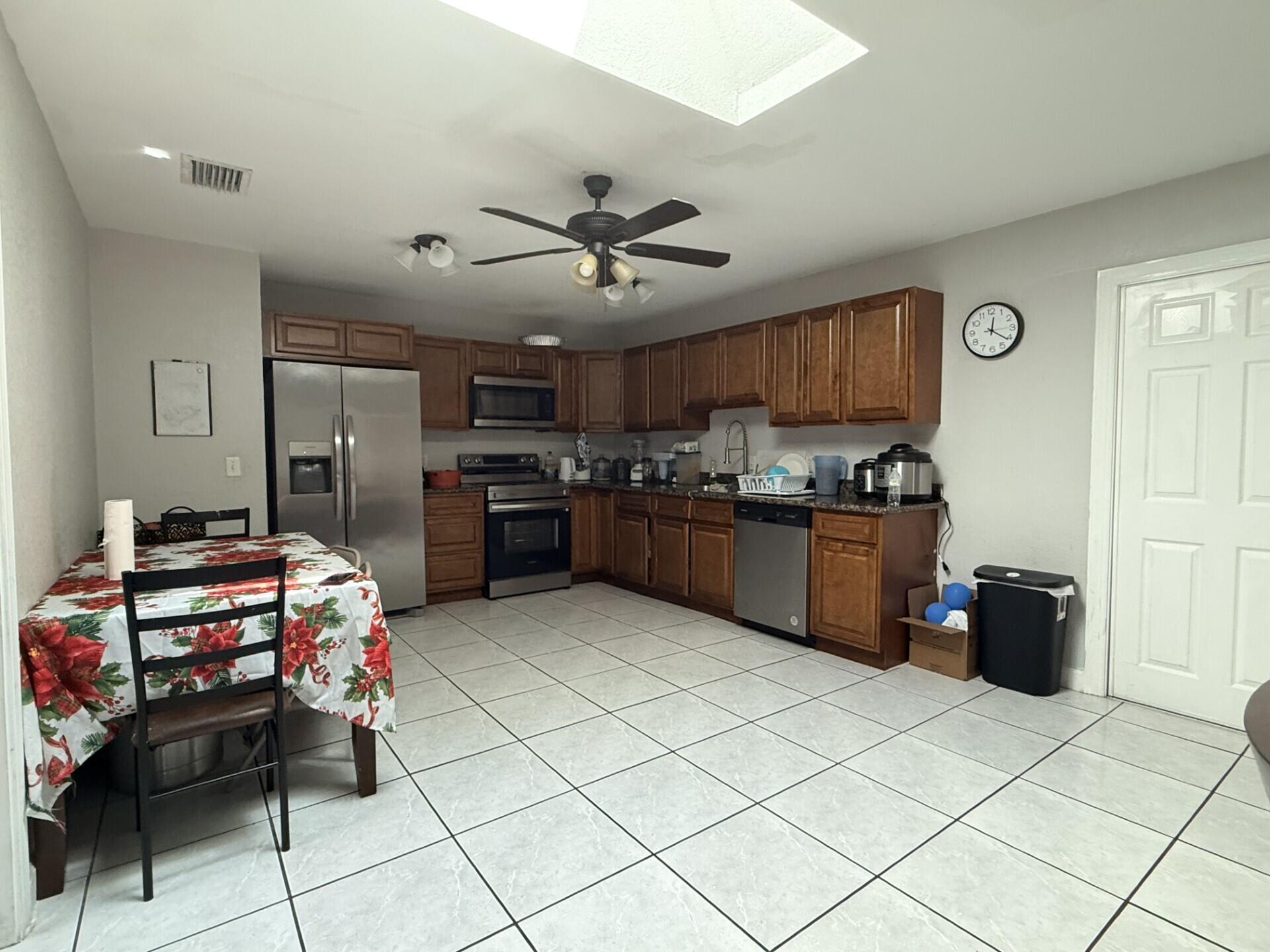 4904 Myrtle Drive Fort Pierce, FL 34982 - Photo 8 of 18 a kitchen with stainless steel appliances granite countertop a refrigerator and a stove top oven