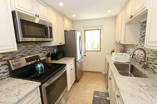 a kitchen with a sink stove top oven and refrigerator