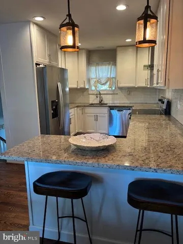 a kitchen with stainless steel appliances granite countertop a sink refrigerator and cabinets