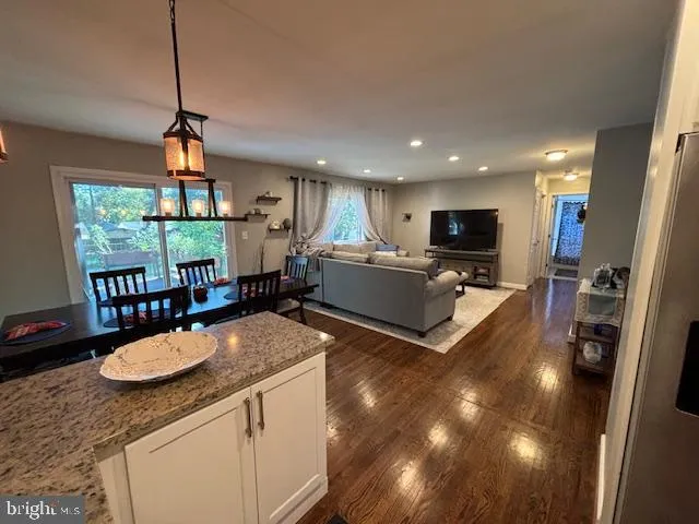 a kitchen with sink a refrigerator and chairs