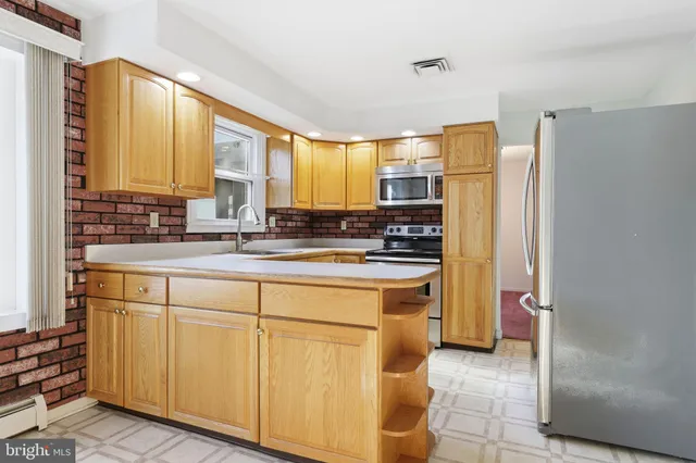 a kitchen with stainless steel appliances a refrigerator sink and cabinets