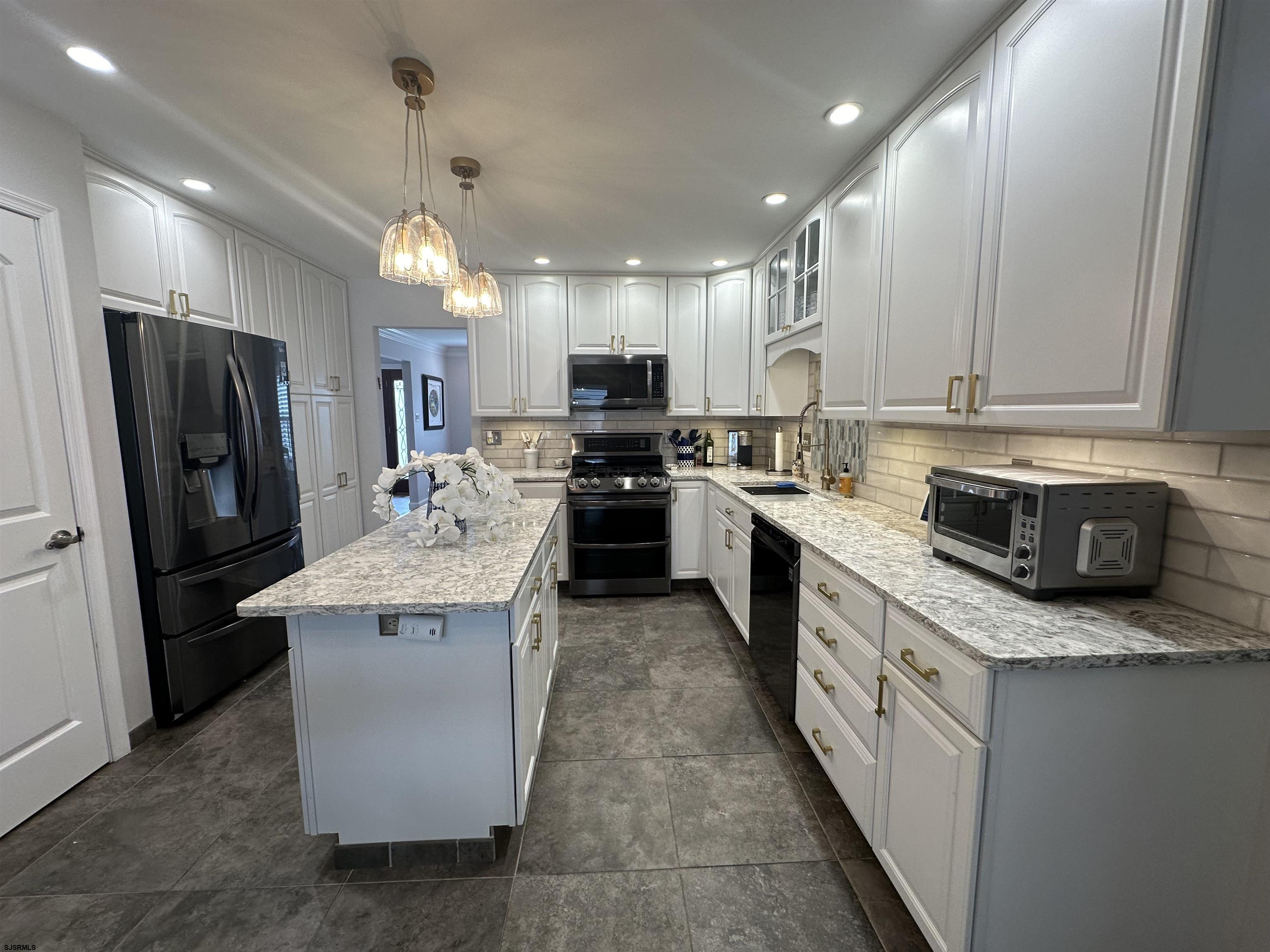 5701 Ventnor Avenue, Unit 5/217/31 Ventnor City, NJ 08406 - Photo 13 of 44 a kitchen with stainless steel appliances granite countertop a stove top oven a refrigerator a sink and dishwasher