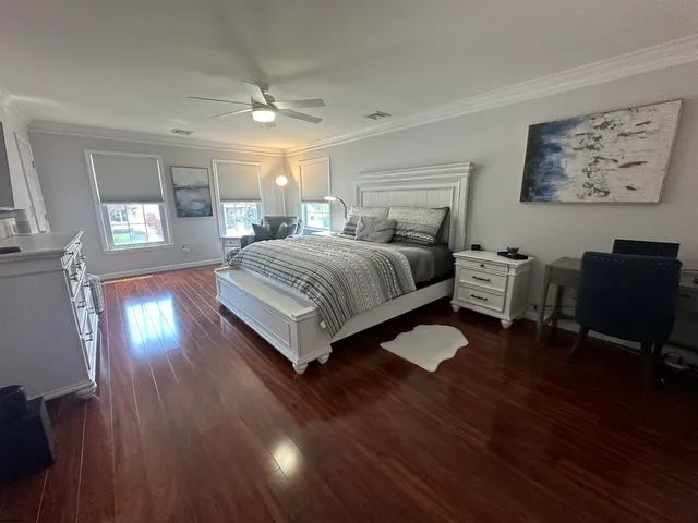 a bedroom with a bed lamps and wooden floor