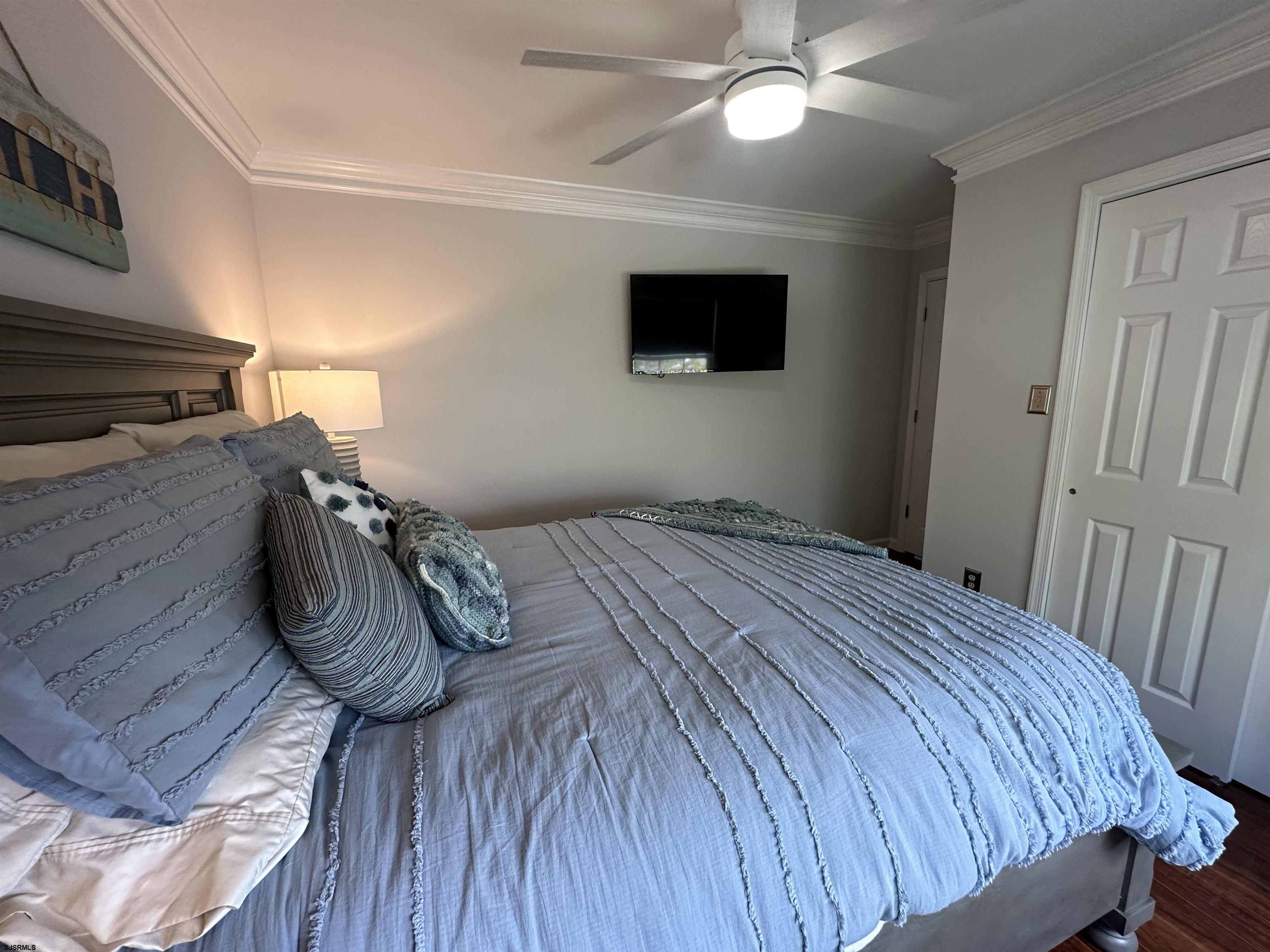 5701 Ventnor Avenue, Unit 5/217/31 Ventnor City, NJ 08406 - Photo 32 of 44 a bedroom with a bed and a flat screen tv