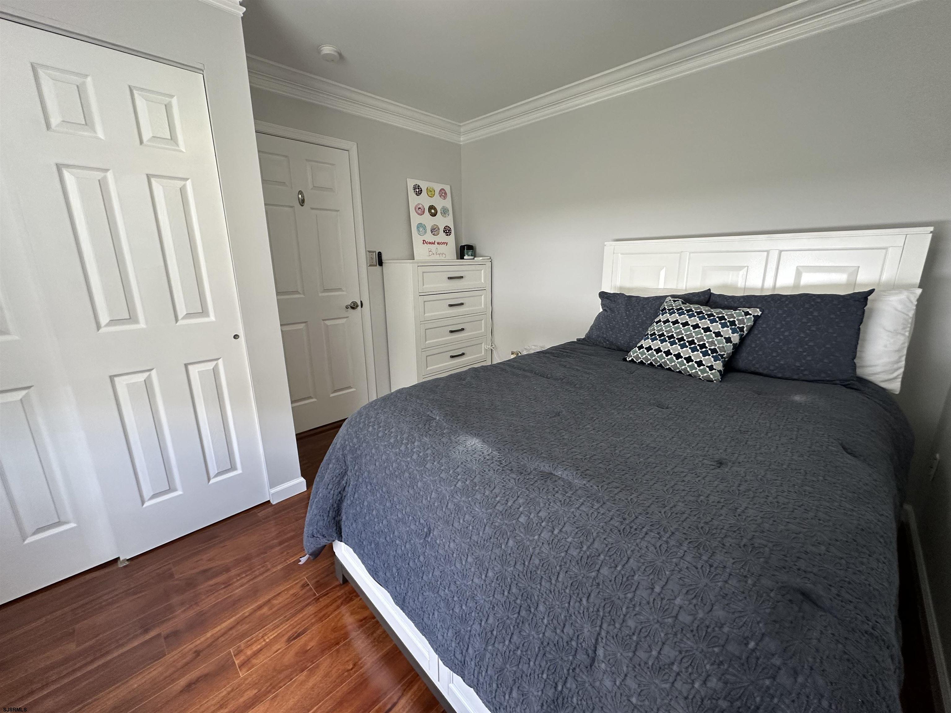 5701 Ventnor Avenue, Unit 5/217/31 Ventnor City, NJ 08406 - Photo 34 of 44 a bedroom with a bed and wooden floor