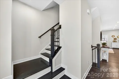 a view of hallway with stairs and wooden floor
