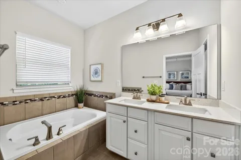 a bathroom with a tub sink and mirror