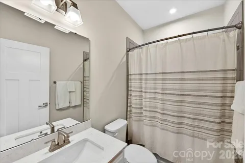a bathroom with a sink mirror vanity and toilet