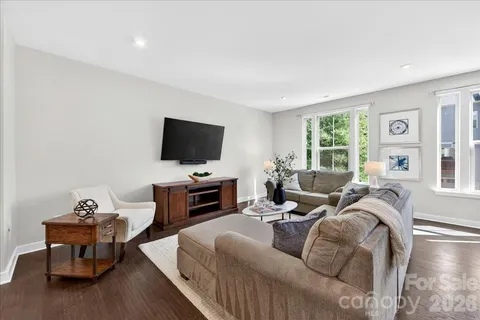 a living room with furniture a flat screen tv and a large window