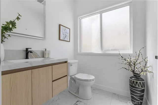 a bathroom with a toilet a sink and a window