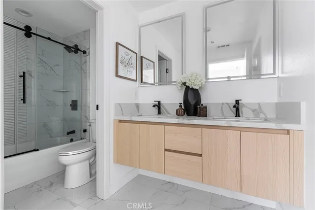 a bathroom with a double vanity sink toilet and shower