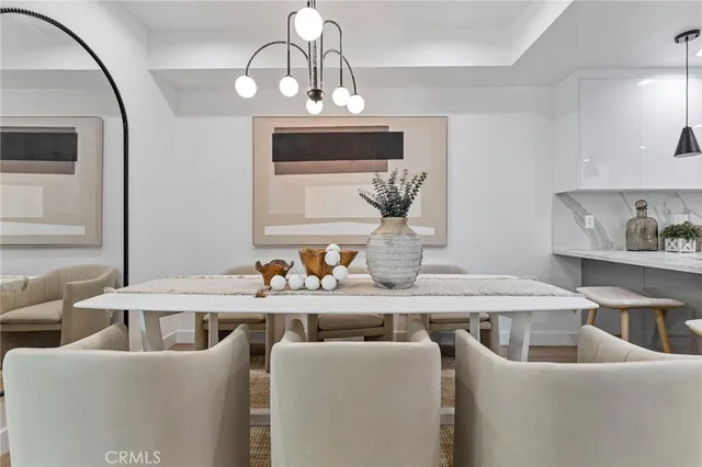 a dining room with furniture a chandelier and wooden floor