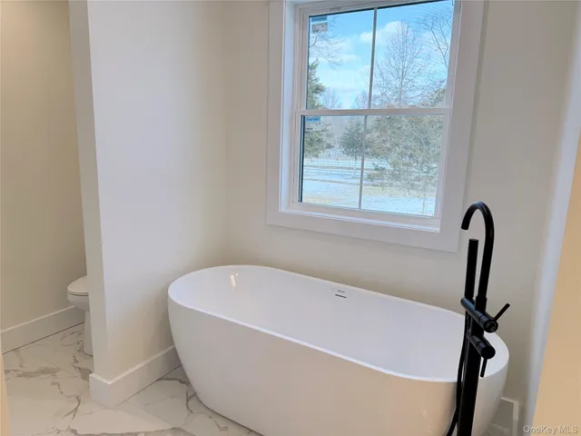 an empty room with wooden floor ceiling fan and windows