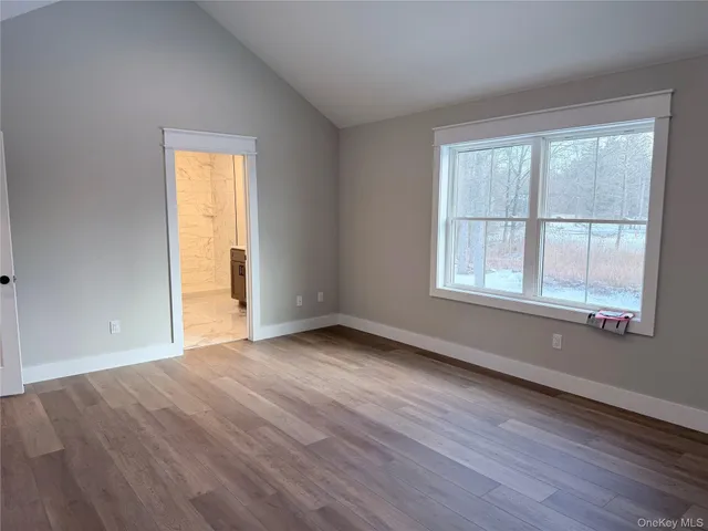 a view of a small space with wooden floor and a window