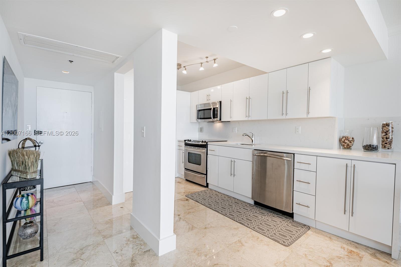 100 Lincoln Road, Unit 944 Miami Beach, FL 33139 - Photo 5 of 40 a kitchen with white cabinets and appliances