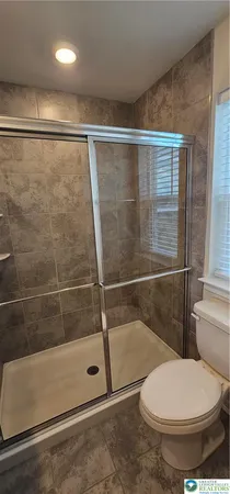 a bathroom with a toilet and a shower