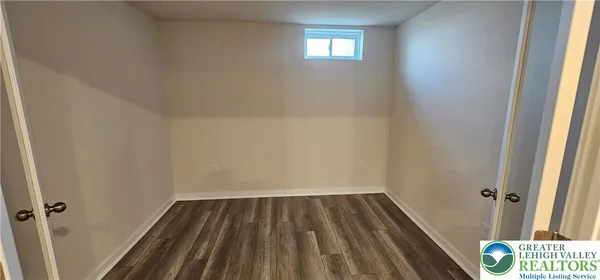 a view of a room with wooden floor and small window